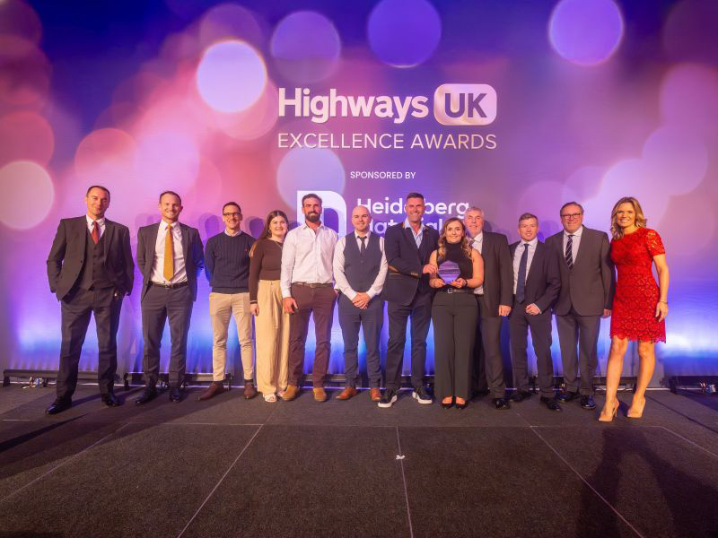 A group of people on a stage receiving an award. Background states Highways UK